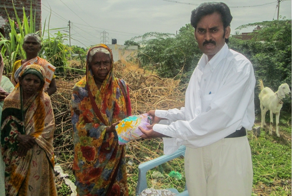 Pastor David giving new sari to widow in India
