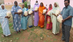 Ladies holding bags of rice